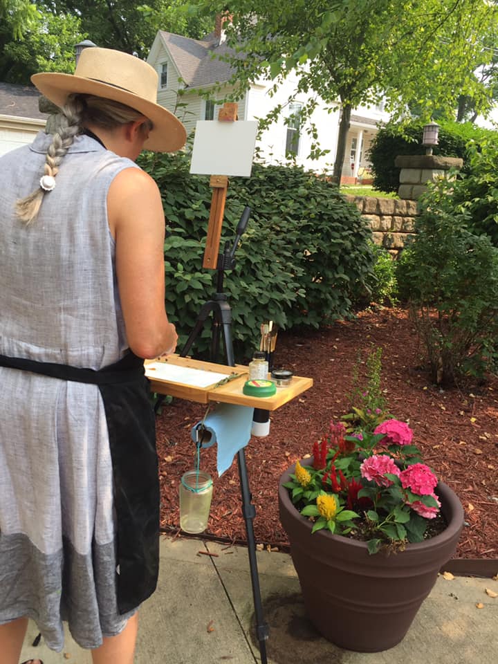 Resident painter in straw hat working outdoors